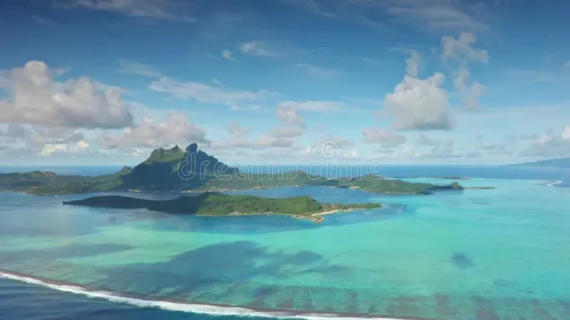 Aerial view of Bora Bora island with volcanic peak surrounded by turquoise waters