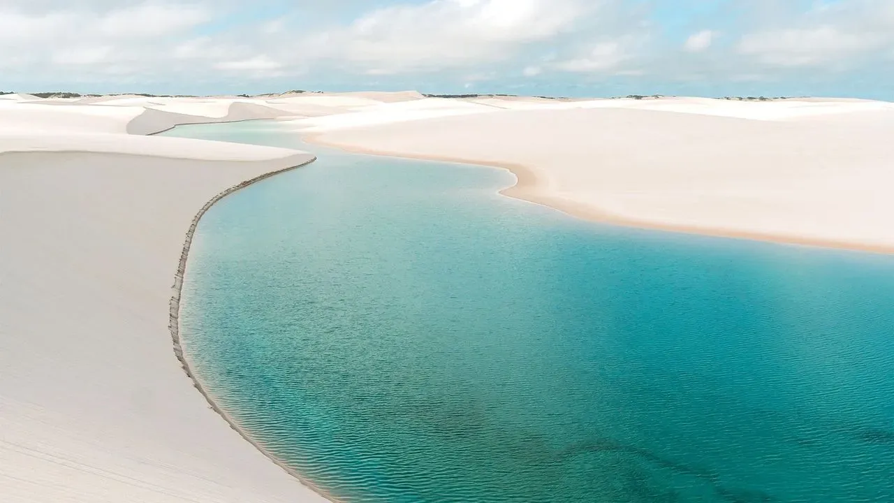 Swimming lagoon surrounded by white sand dunes at Lençóis Maranhenses
