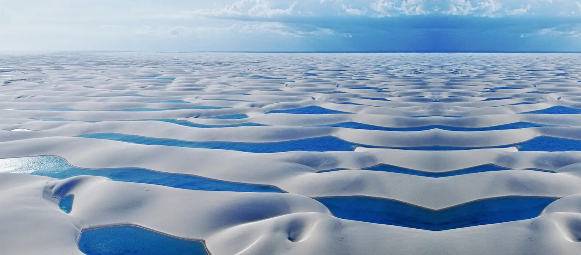 Blue water lagoons among white sand dunes at Lençóis Maranhenses