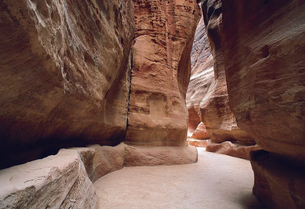 The narrow Siq gorge at Petra Jordan with towering rose-red sandstone walls
