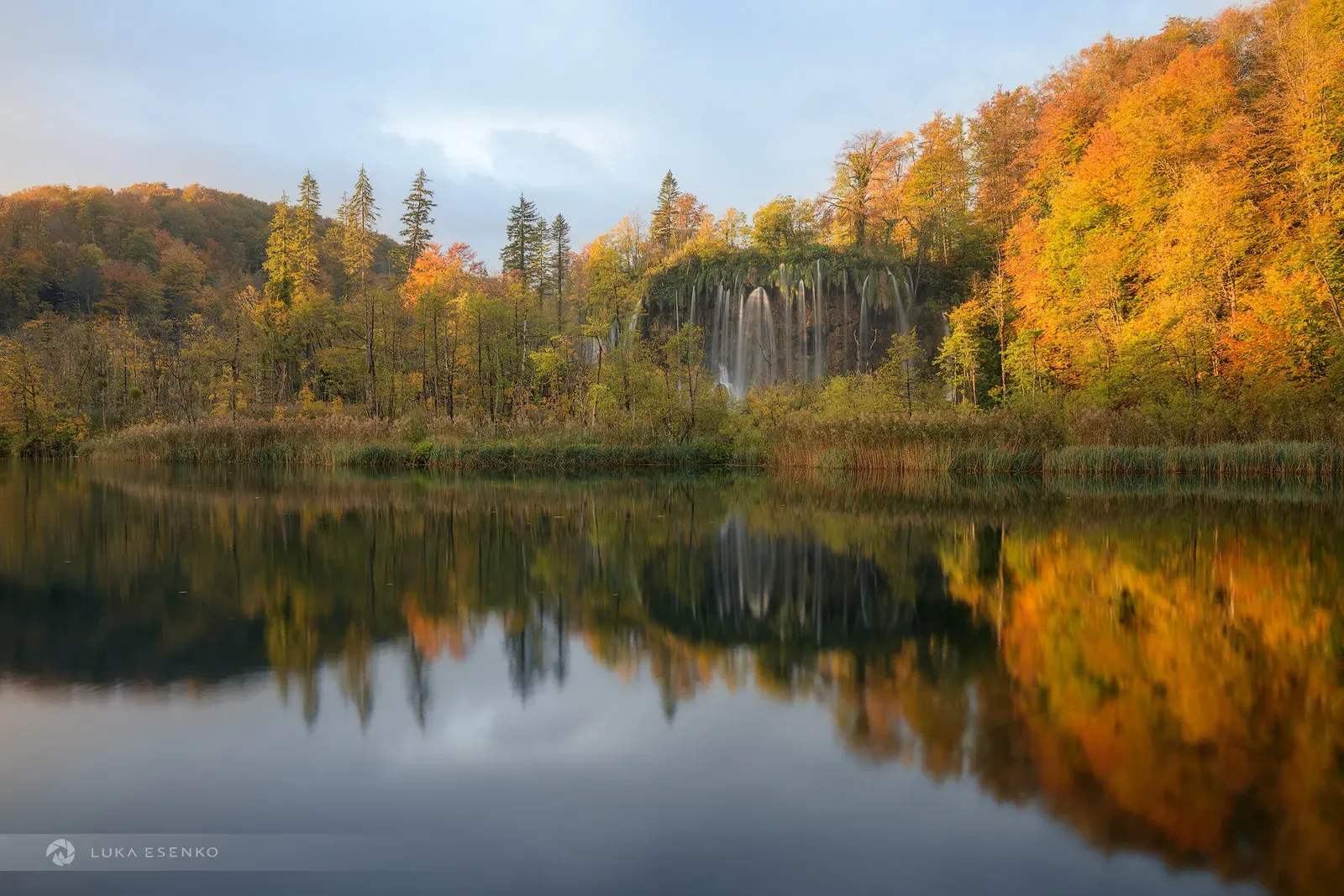 Autumn sunset at Plitvice Lakes with golden light illuminating waterfalls