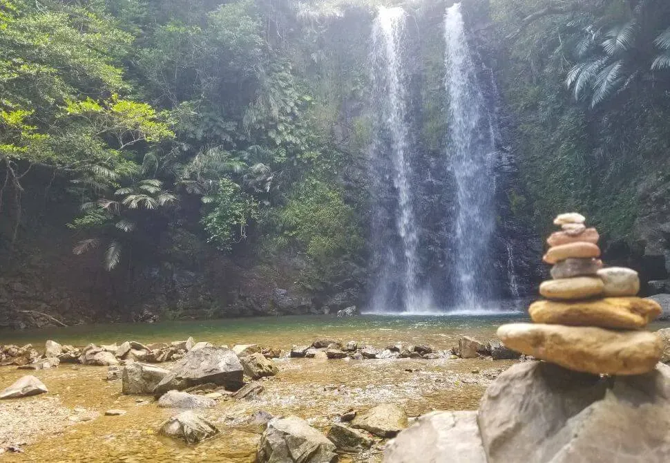 Balanced rock stack with Taataki Waterfall in background at Taataki Waterfall Japan
