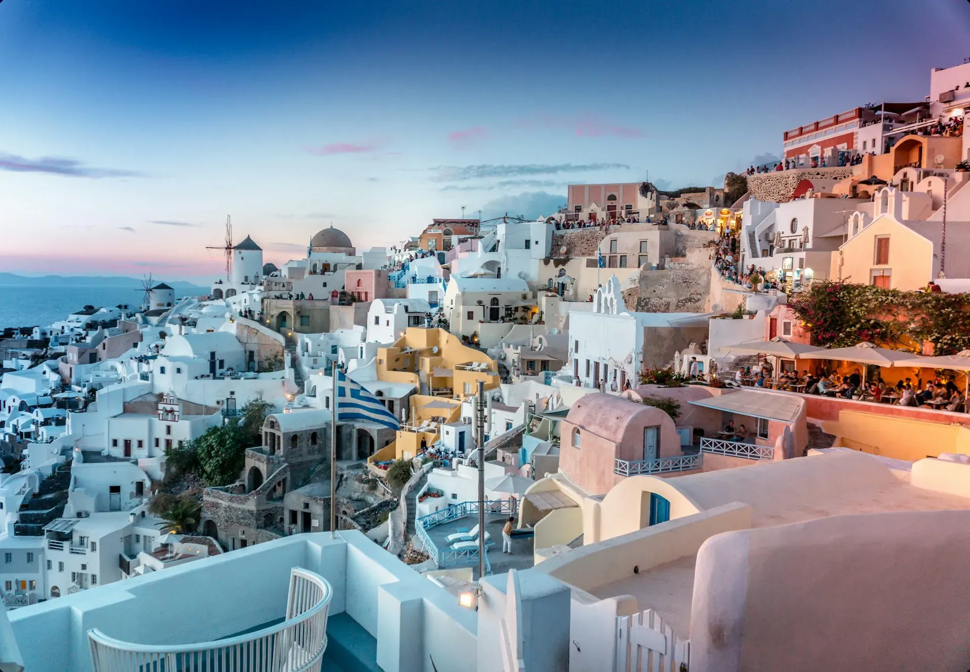 Pink and gold sunset over the Aegean Sea with whitewashed buildings