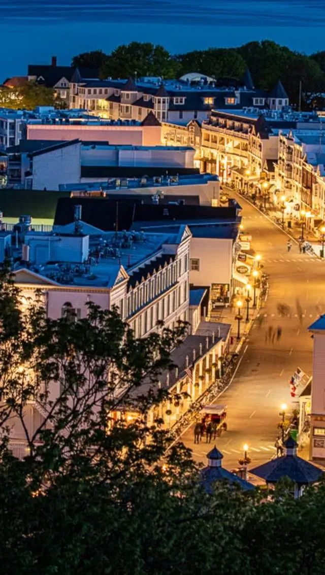 Evening scene with illuminated historic storefronts and vintage streetlamps