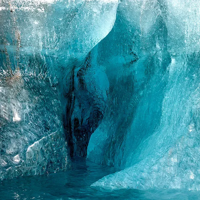 Close up of striking blue ice formations inside a Svalbard ice cave with intricate texture