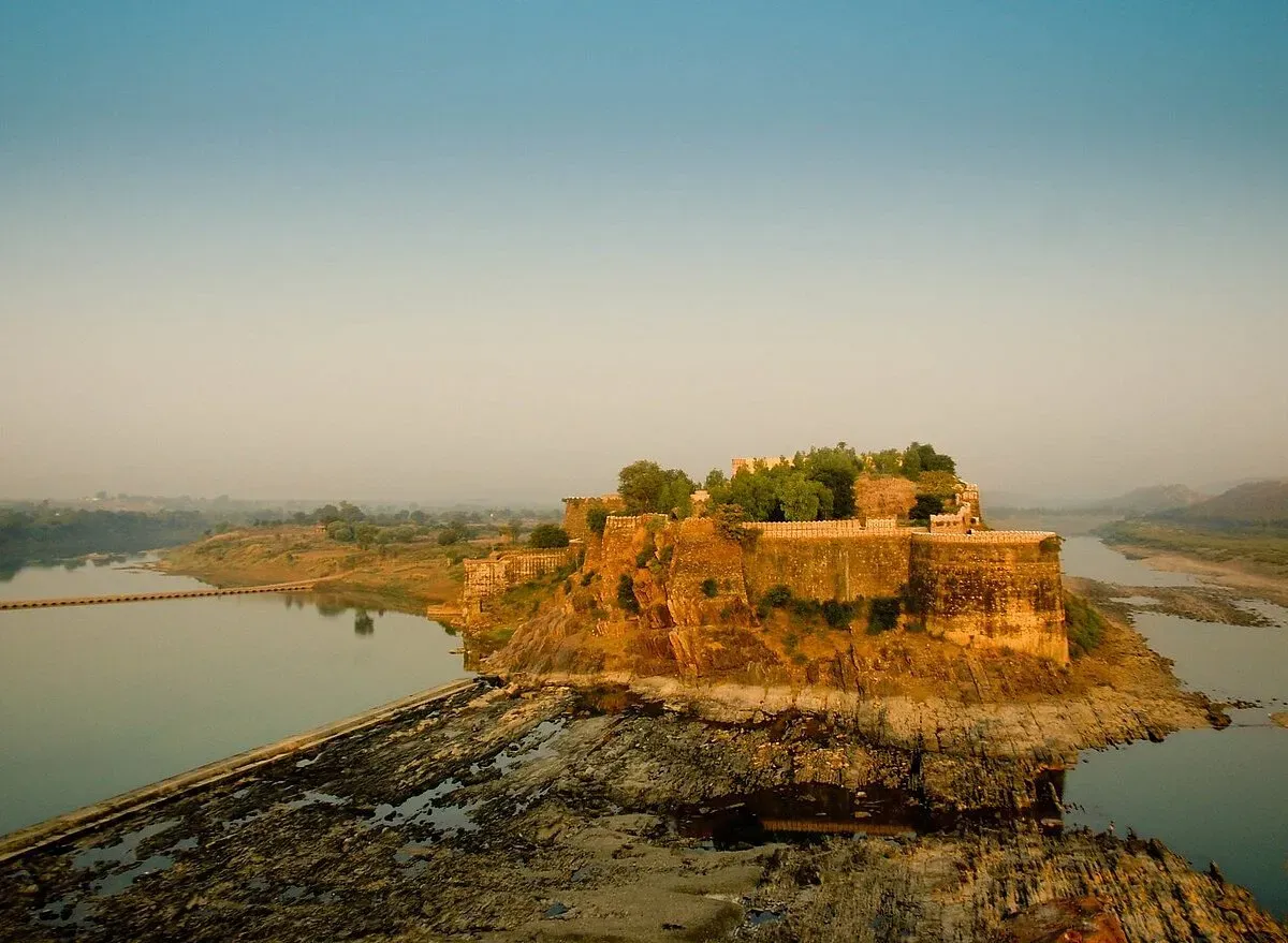 Gagron Fort perched on a rocky island surrounded by calm water at golden hour