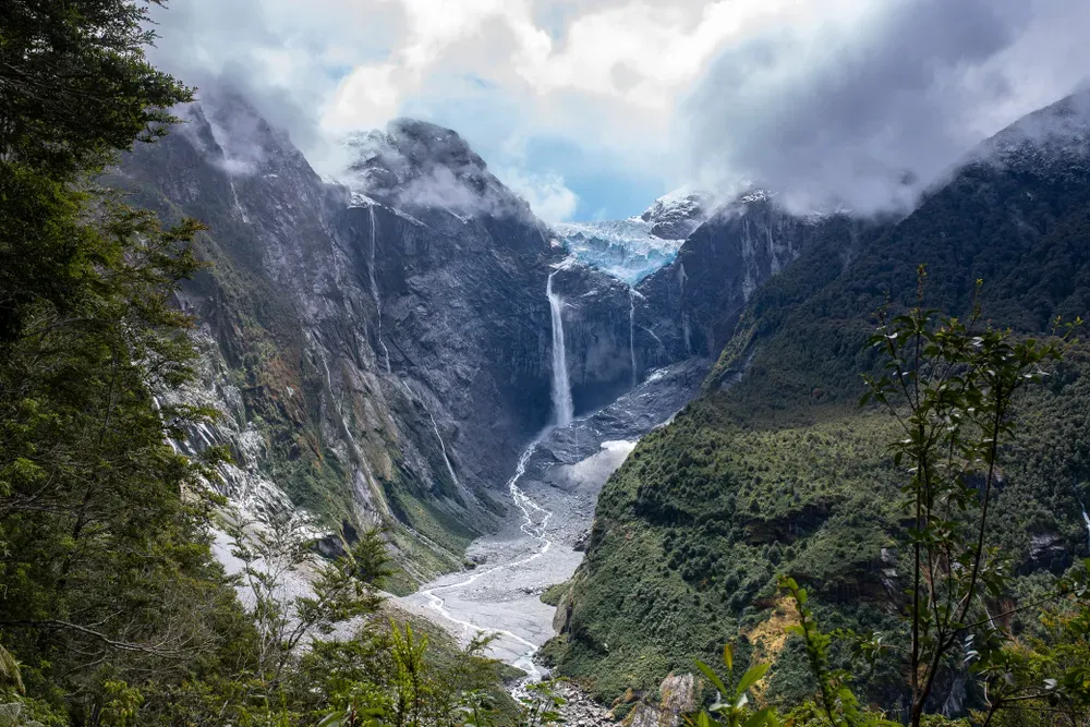 Hanging glacier cascading waterfall and glacial river in Queulat National Park