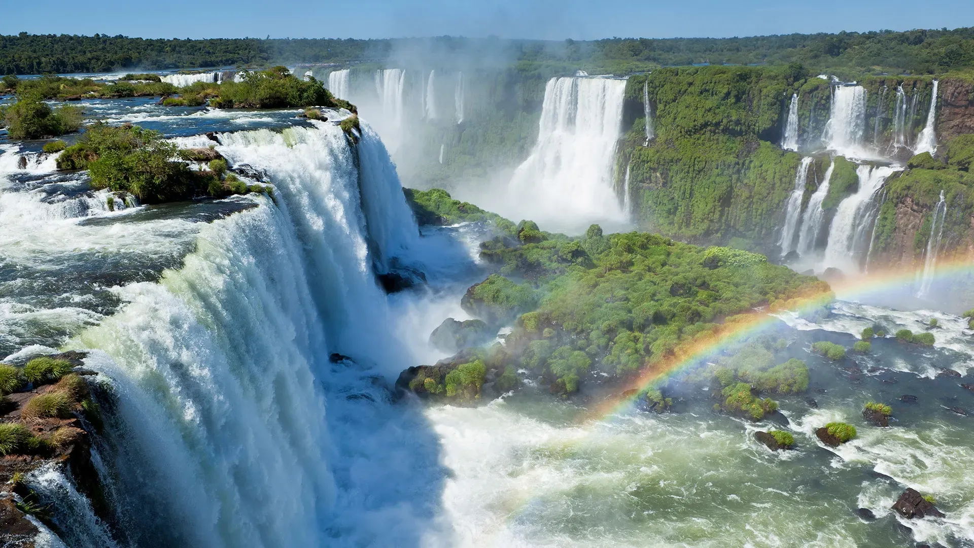 Iguazu Falls Argentina with a vibrant rainbow arcing over the cascading water