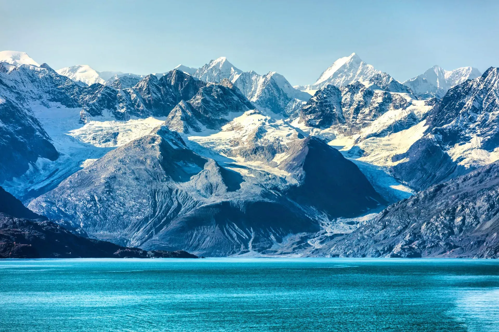 Jagged snow-capped peaks rising above turquoise glacial waters