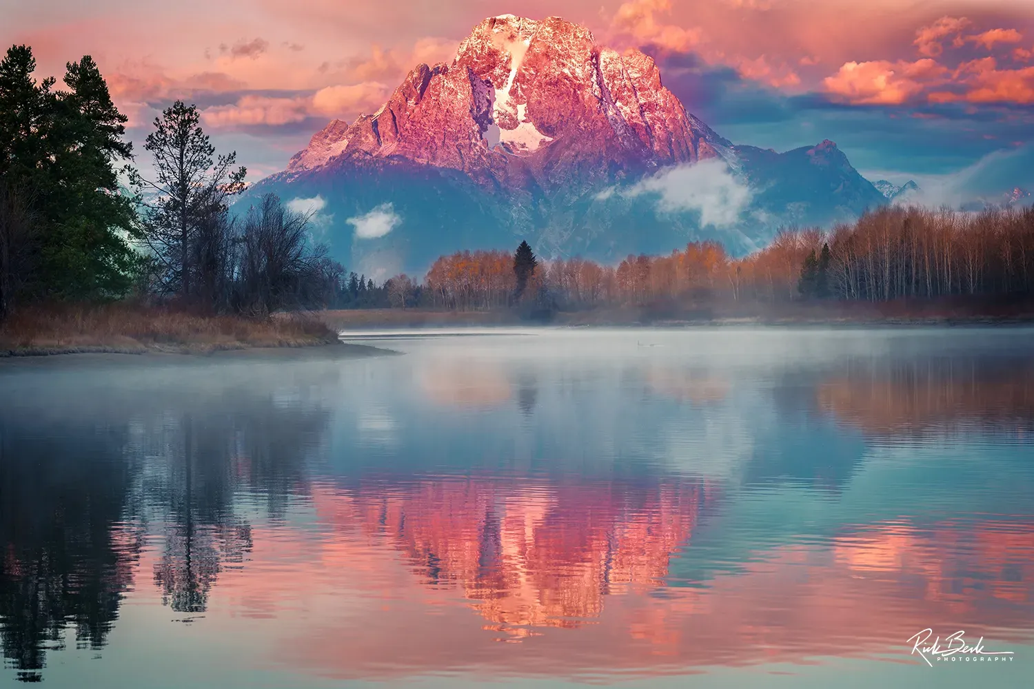 Mount Moran bathed in warm alpenglow reflected in Oxbow Bend