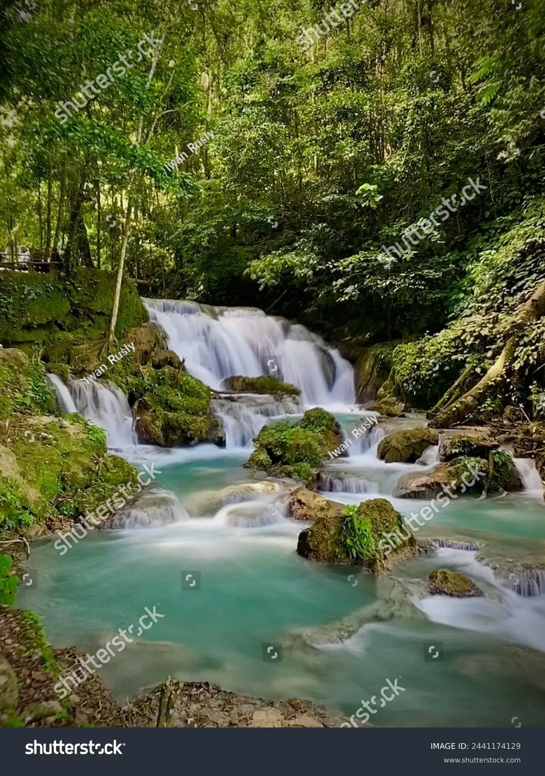 Multi-tiered Piala waterfall turquoise water over mossy limestone