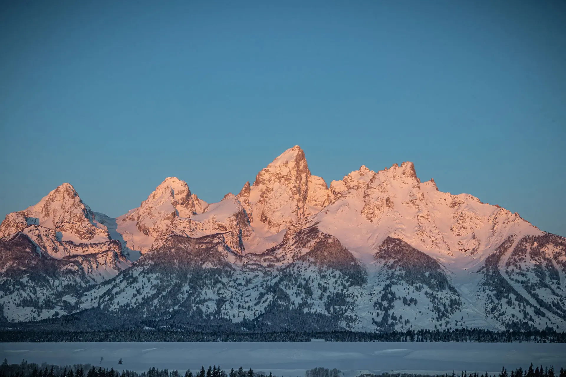Snow-covered Grand Teton peaks above a winter landscape
