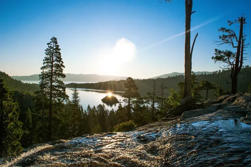 Sunrise over Eagle Falls in Lake Tahoe with cascading water flowing into the turquoise lake surrounded by rocks