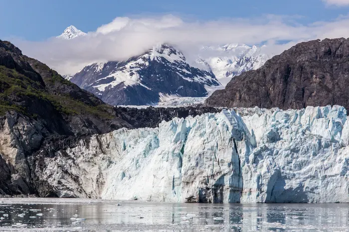 Tidewater glacier calving with ice chunks breaking into the bay