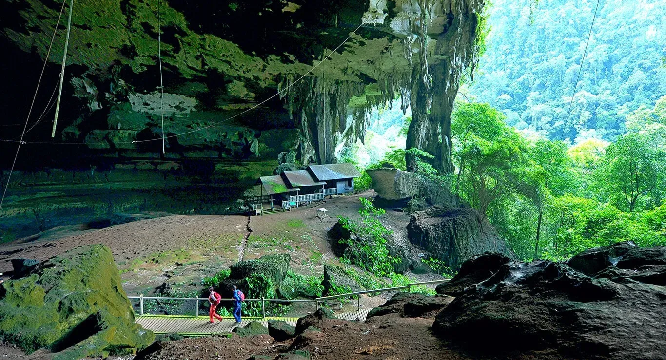 Visitors walking along wooden boardwalk through Niah Caves Malaysia