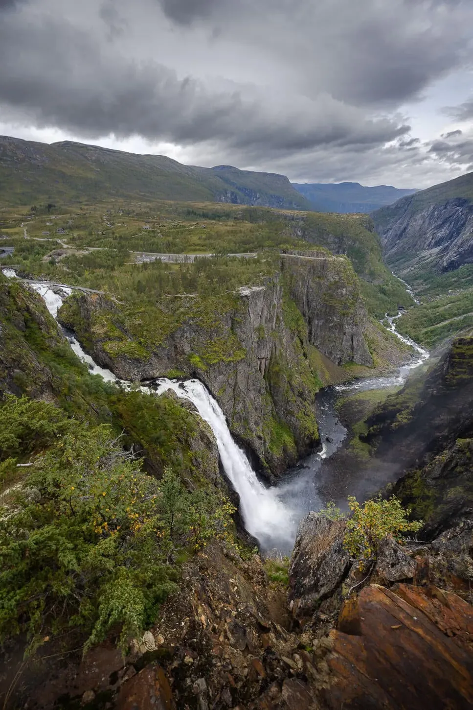 Vøringsfossen waterfall under dramatic dark stormy skies with mist swirling