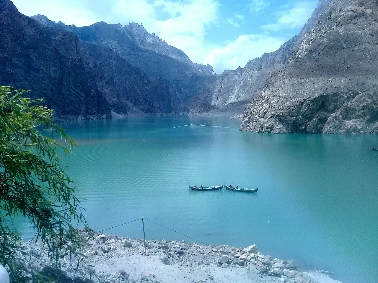 Wide-angle view of Attabad Lake Pakistan with vivid turquoise water and steep rocky canyon walls