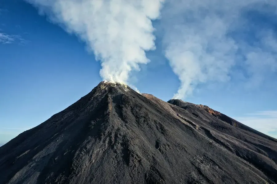 Close-up aerial view of Mount Karangetang's twin craters actively smoking on Siau Island, North Sulawesi, Indonesia