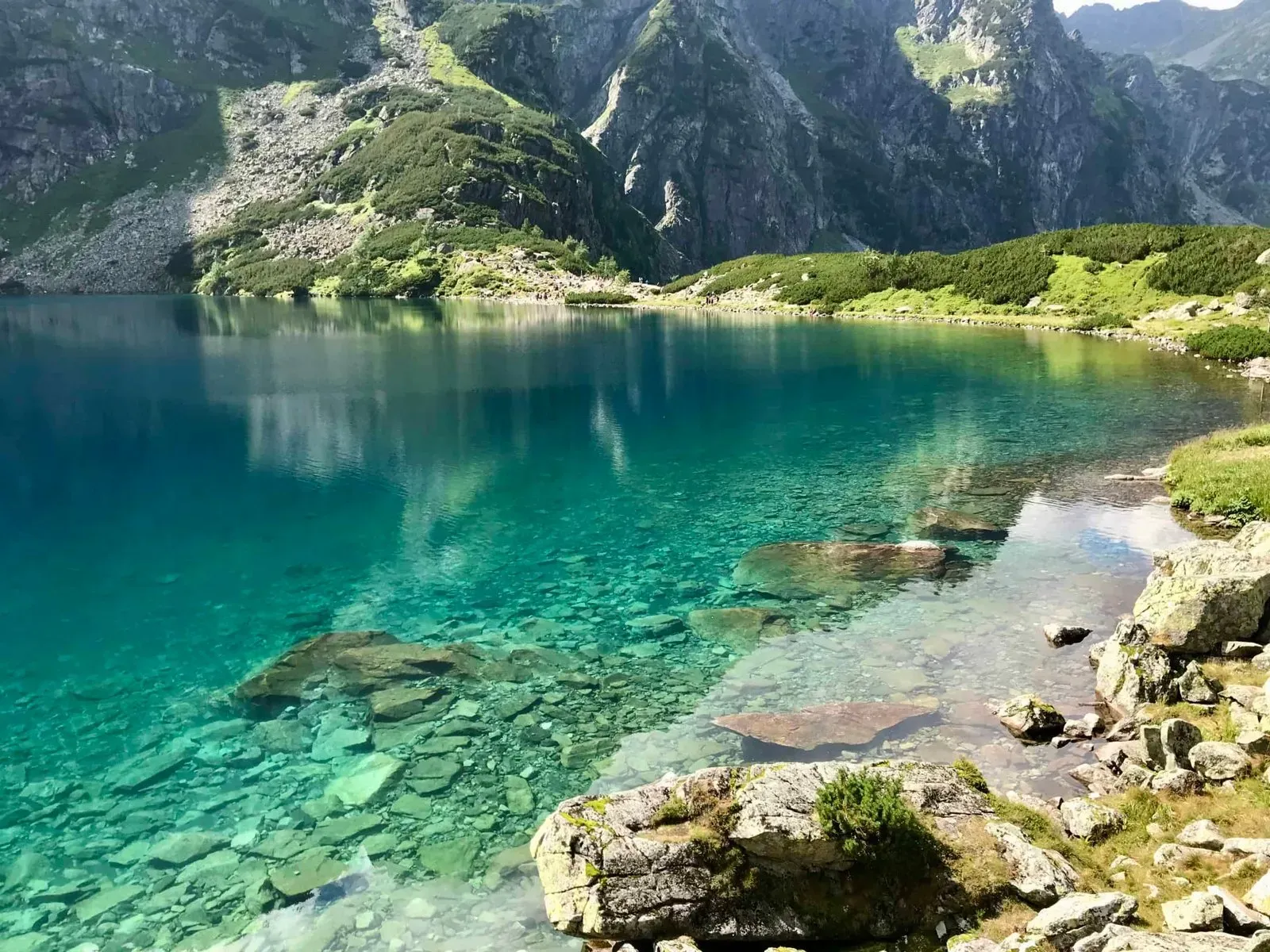 Close-up of the clear turquoise waters of Morskie Oko with rocky shores and rugged mountain slopes