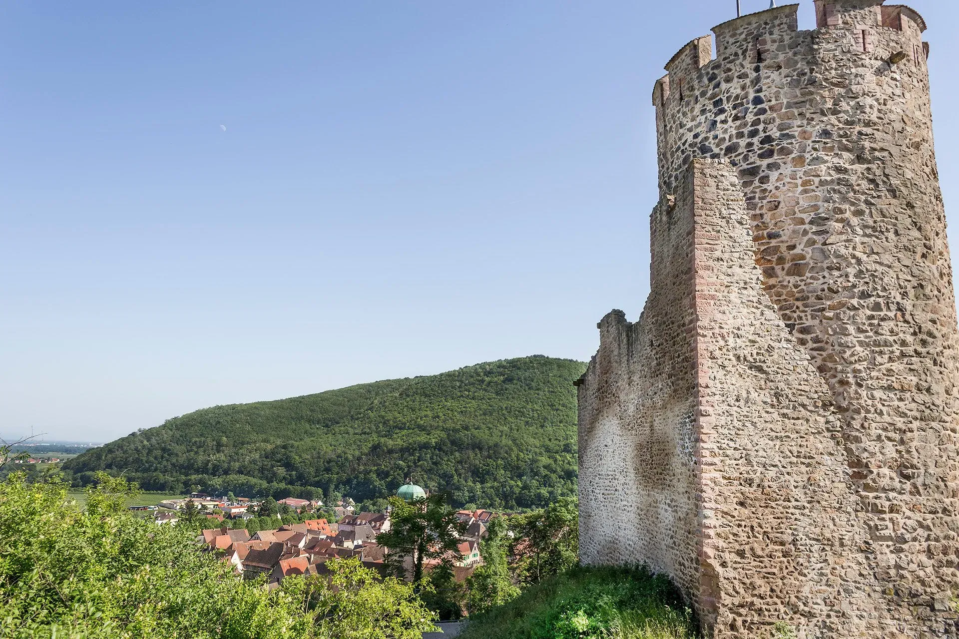 Close-up view of Kaysersberg Castle stone tower and ruined walls against a bright blue sky in France