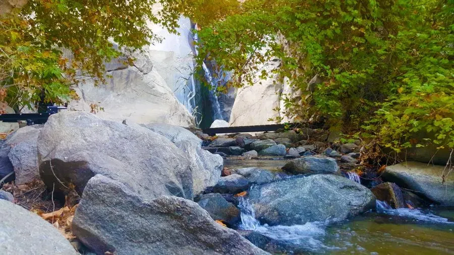Close-up view of Tahquitz Canyon waterfall dropping over granite rocks into a clear pool