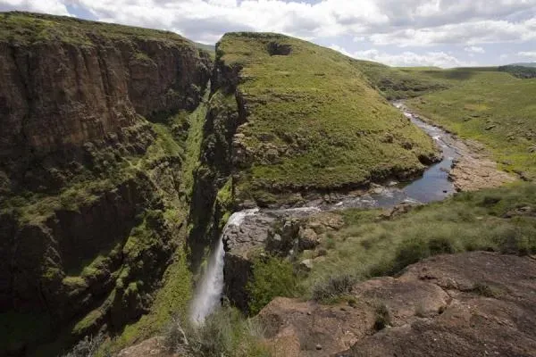 Maletsunyane Falls Lesotho cascading from a green hillside into a steep rocky canyon near Semonkong