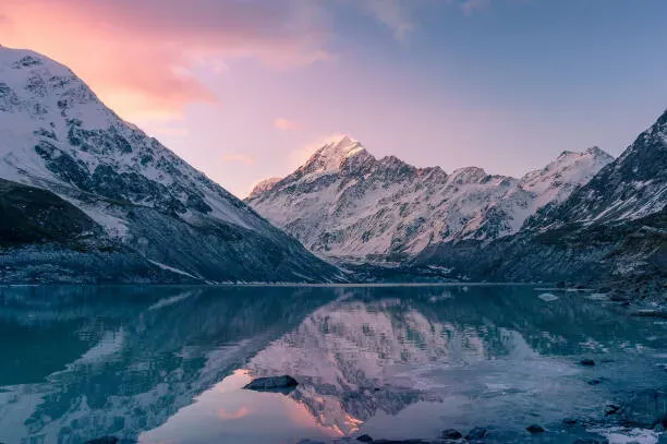 Panoramic view of Kolsai Lakes Kazakhstan with snow-capped Tien Shan peaks rising above turquoise alpine waters and pine forests