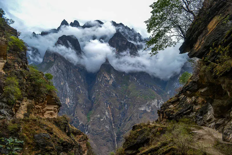 Narrow hiking trail carved into steep rocky cliffs along Tiger Leaping Gorge China