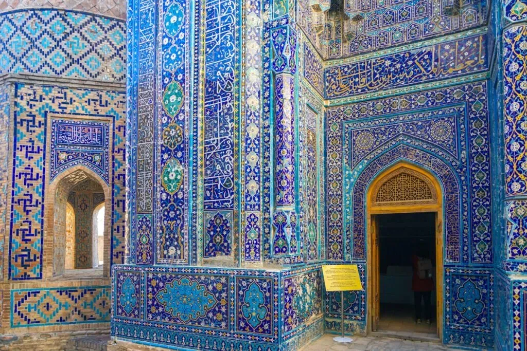 Decorated wall at Shah-i-Zinda covered in blue turquoise tiles and Arabic calligraphy