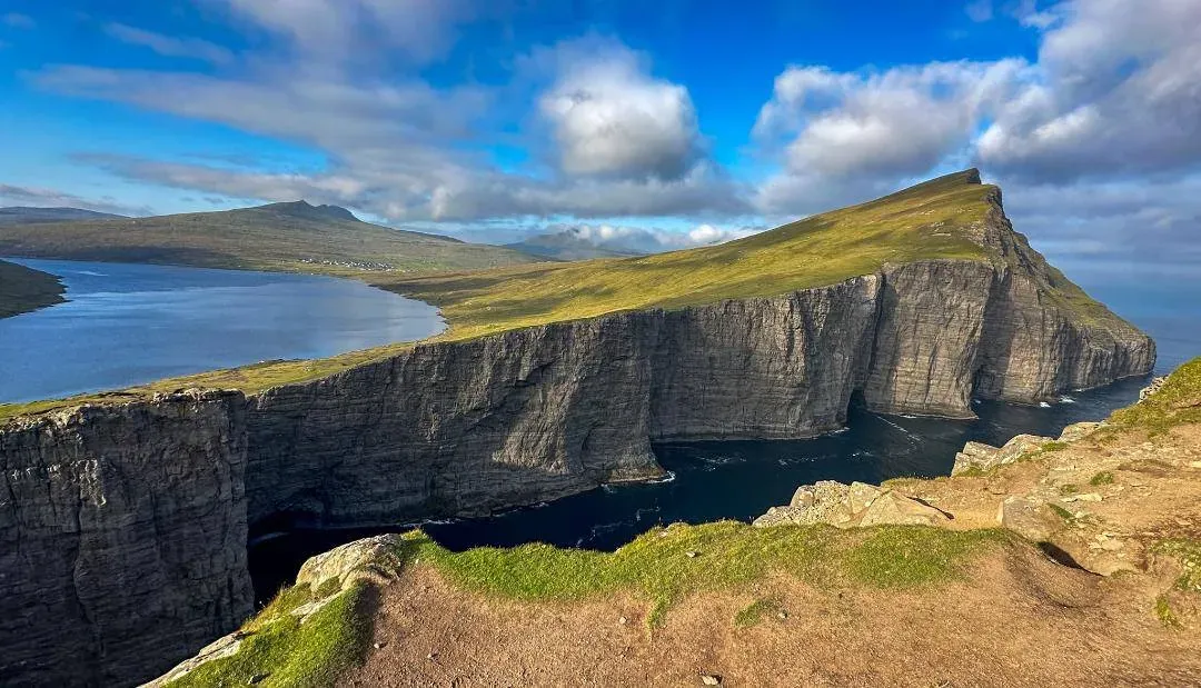 Panoramic view from Trælanípa cliff showing the optical illusion of Lake Sørvágsvatn hovering above the Atlantic Ocean