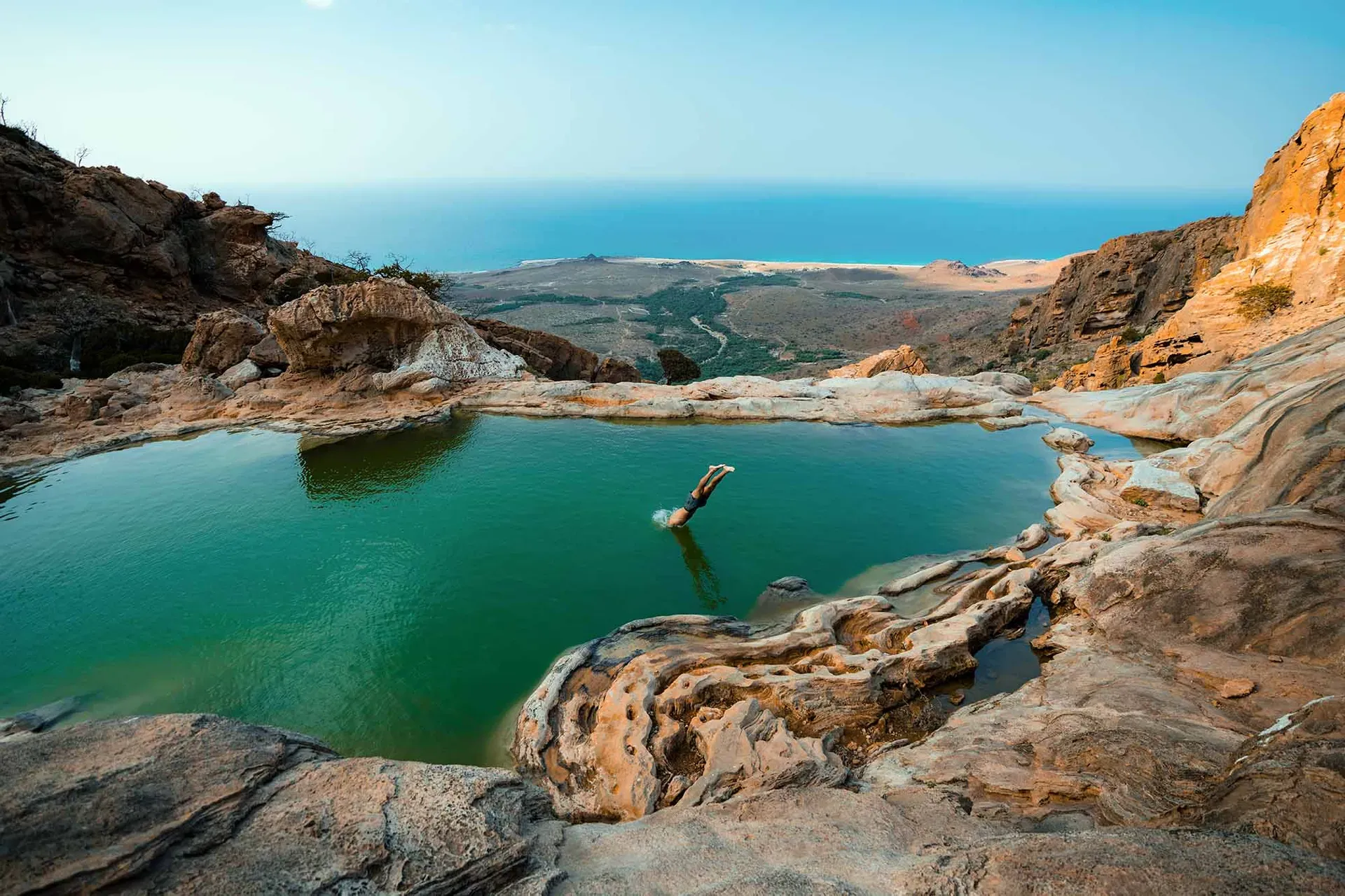 Person diving into natural freshwater pool in Homhil protected area on Socotra Island Yemen