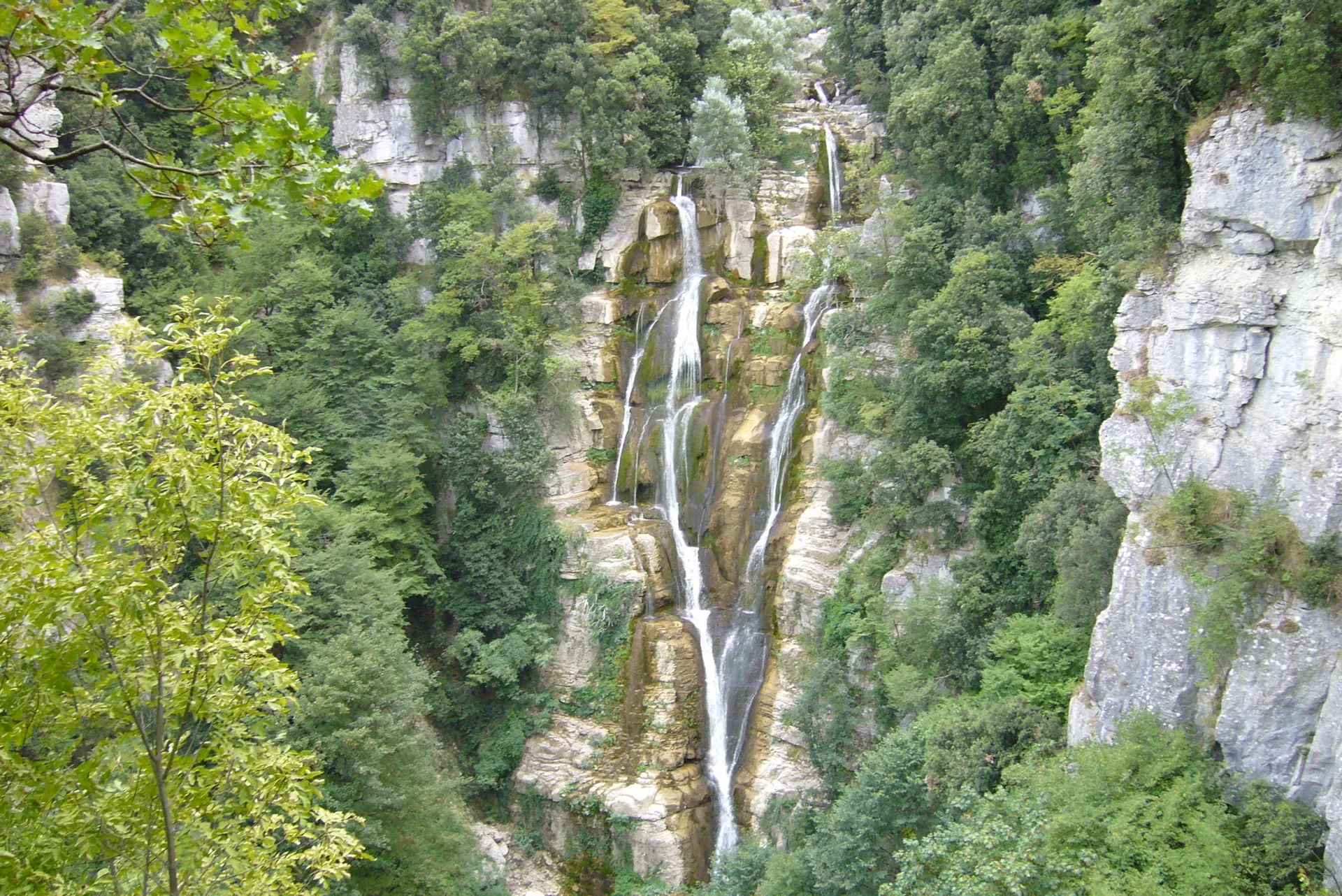 Rio Verde waterfall surrounded by dense autumn foliage in Abruzzo