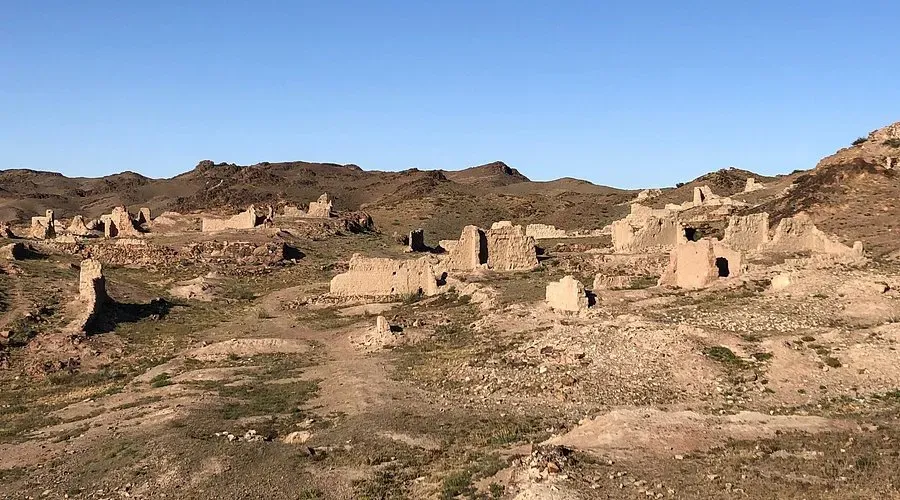 Collapsed brick and timber structures at Ongi Monastery Mongolia scattered across a barren hillside