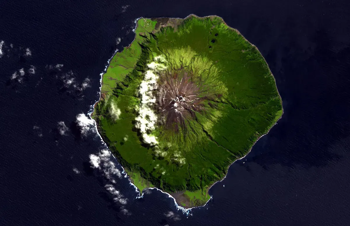 Satellite view of Tristan da Cunha island with Queen Mary's Peak at center surrounded by dark blue ocean