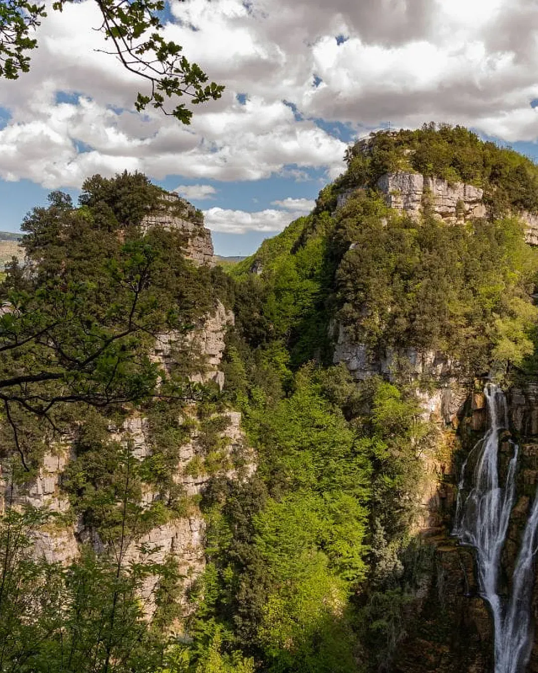 Scenic view of Cascate del Rio Verde in August with rocky cliffs and trees