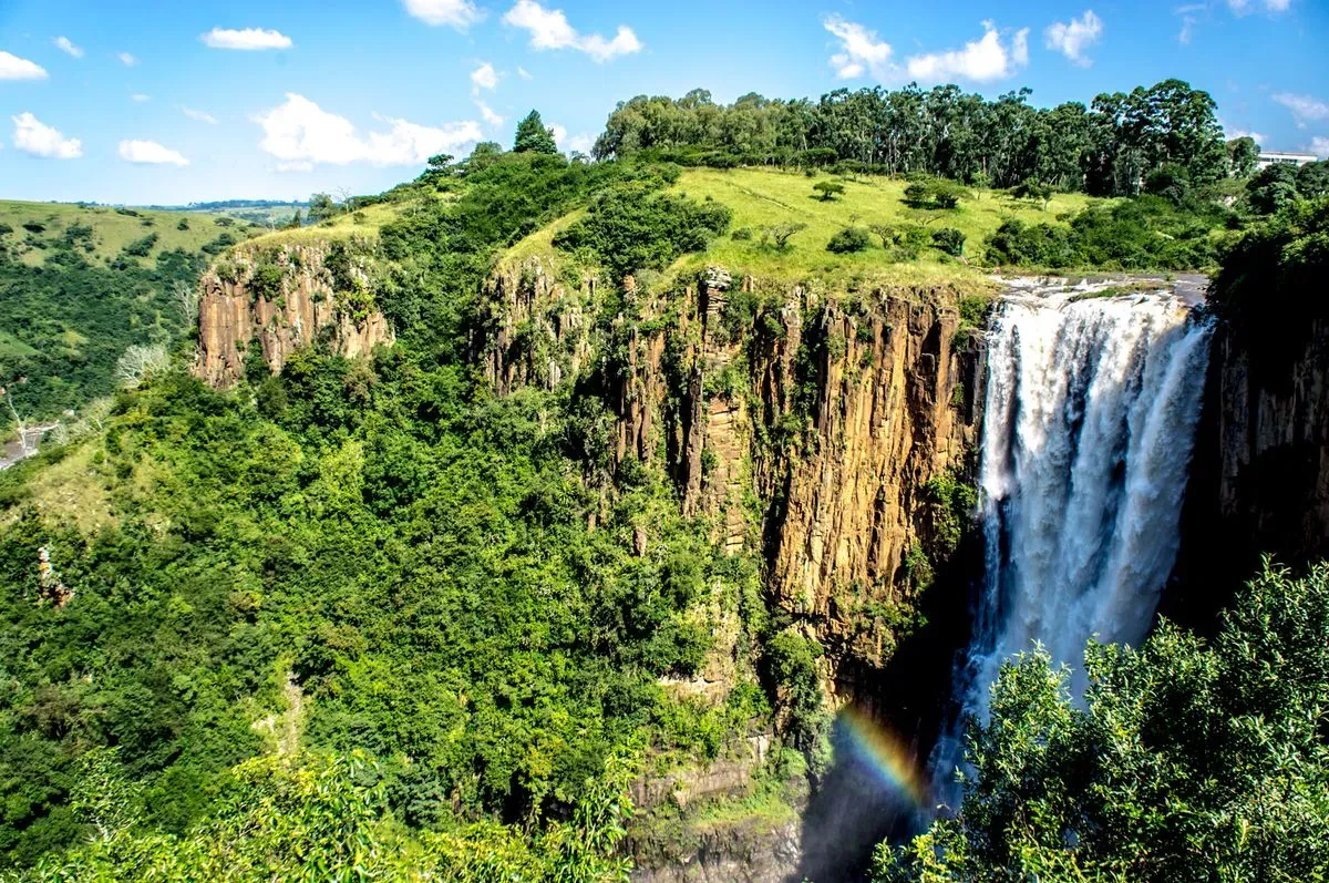 Howick Falls South Africa with a rainbow forming at the base of the waterfall over the Umgeni River pool
