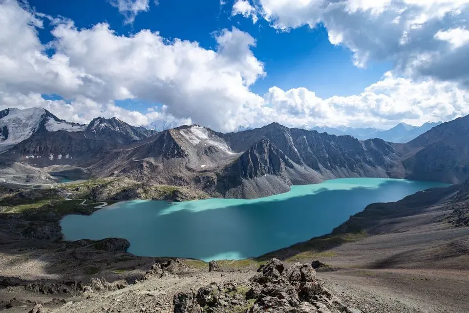 Panoramic view of Ala-Kul Lake Kyrgyzstan with turquoise waters surrounded by Tien Shan mountain peaks