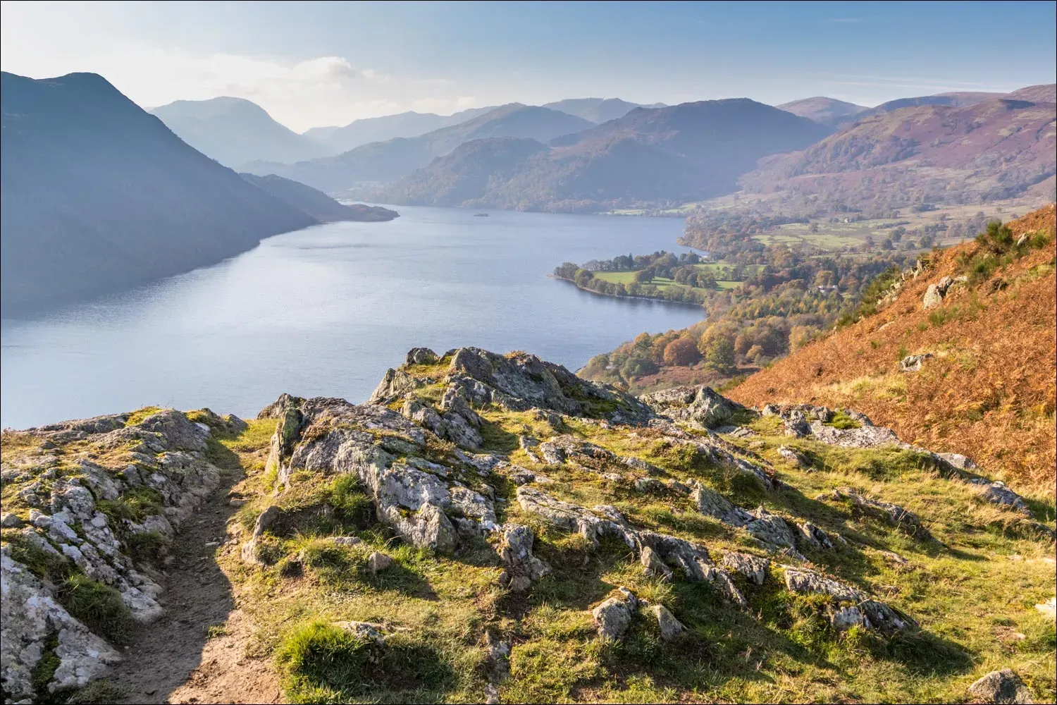 Panoramic view of Ullswater lake in the Lake District with green hills and distant mountains
