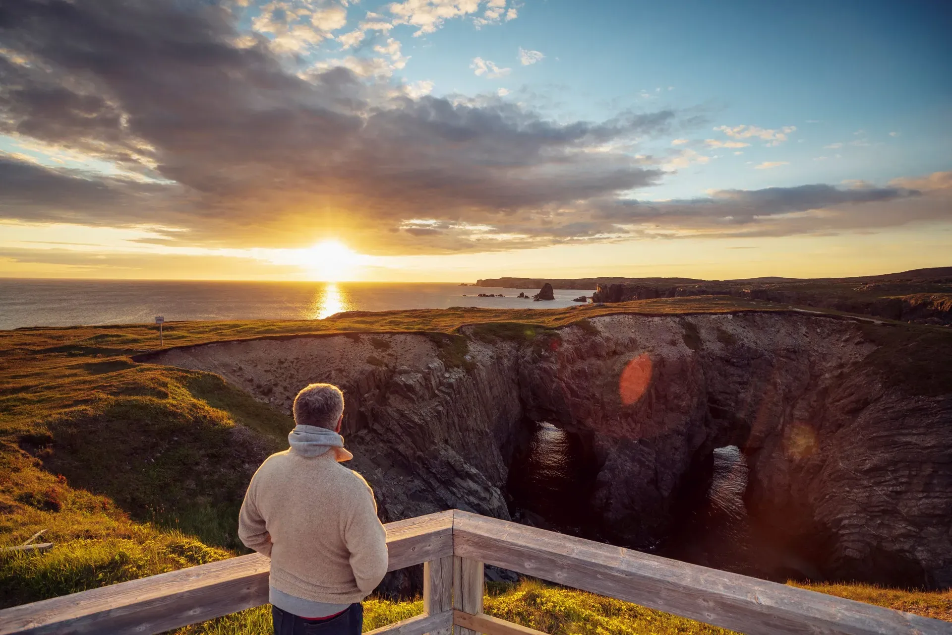 Silhouette at sunset on the viewing platform overlooking the rugged coastline at The Dungeon Bonavista Newfoundland