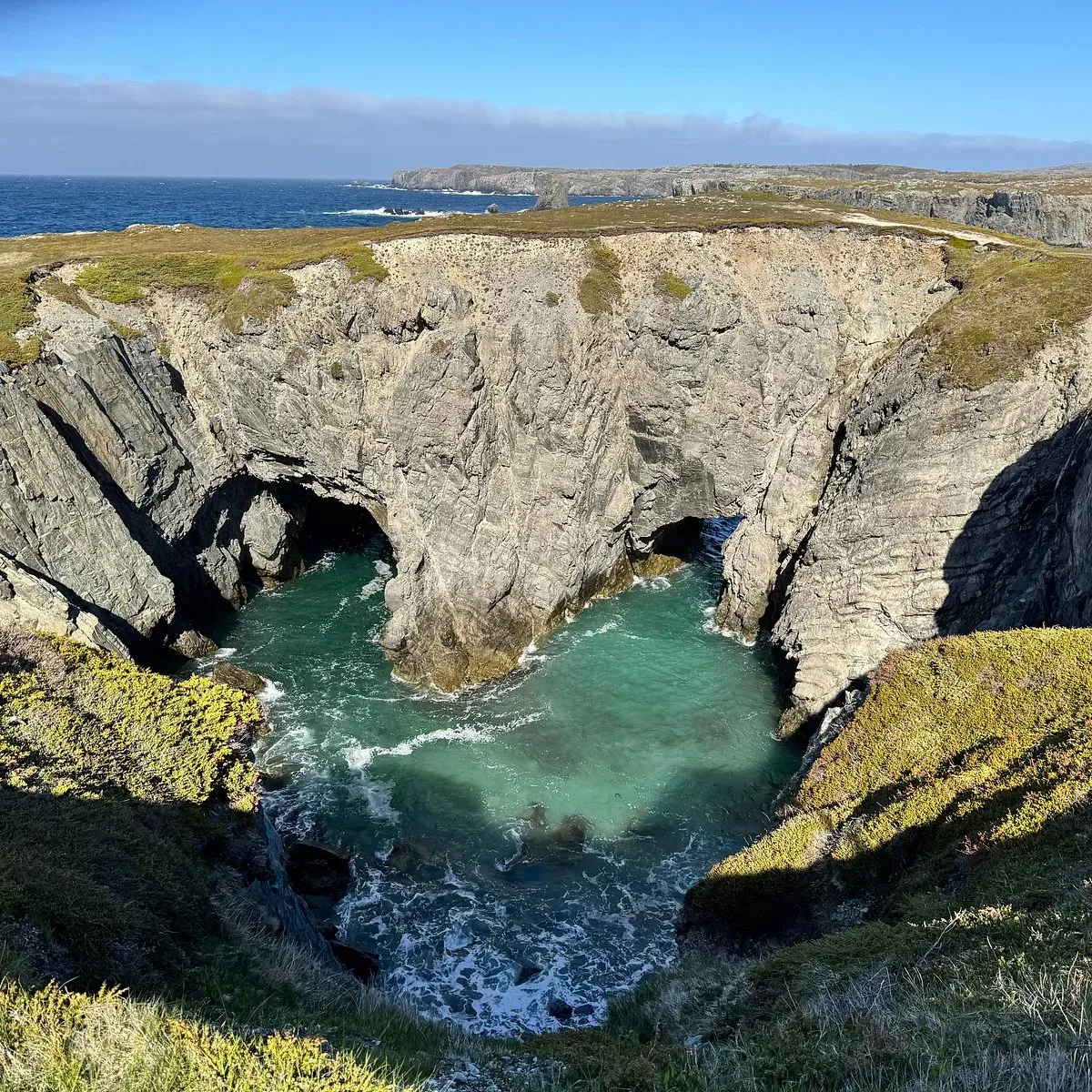 Turquoise Atlantic waves crashing into the Dungeon sea caves and rocky cliffs in Bonavista Newfoundland
