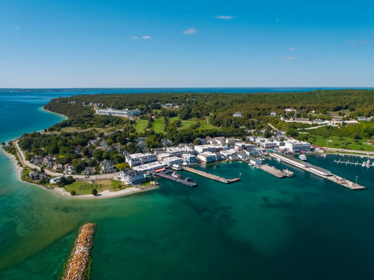 Aerial view of Mackinac Island Michigan with lush green landscapes, charming buildings and marina
