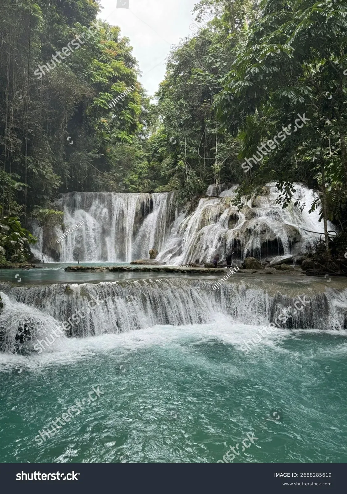 Aerial view of Piala Waterfall Indonesia multi-tiered turquoise cascades surrounded by lush jungle