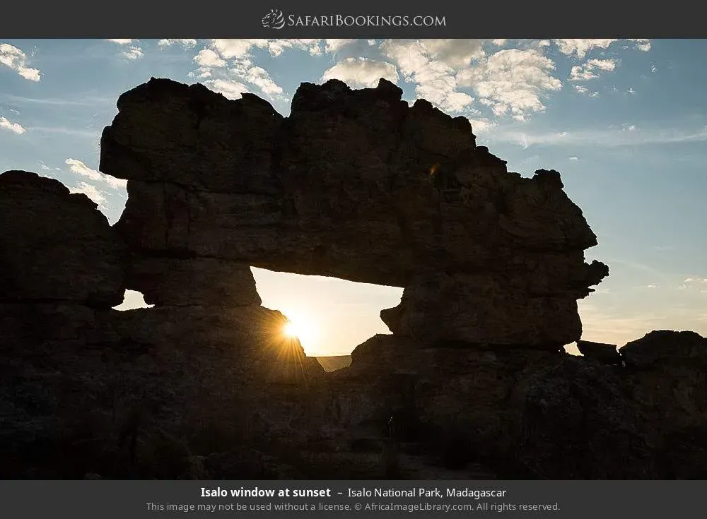 Isalo Window rock formation at sunset with orange and purple sky over sandstone landscape