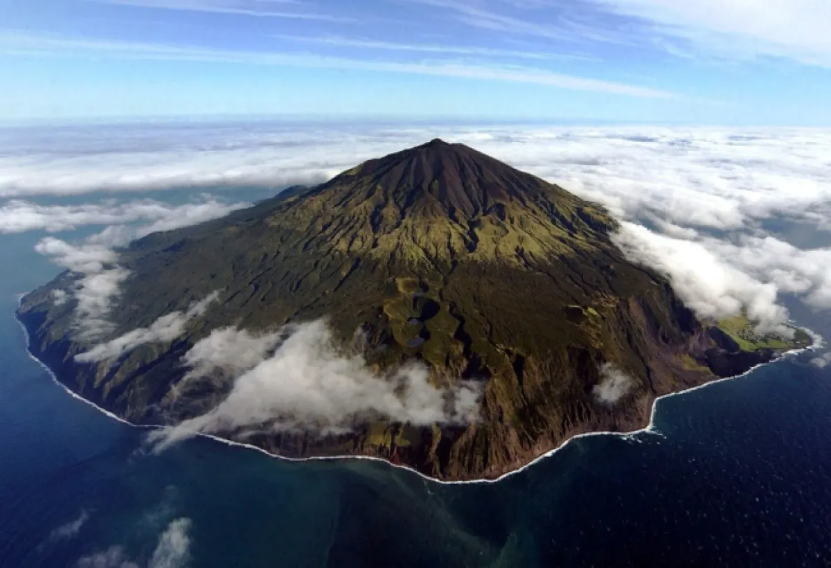 Queen Mary's Peak rising above clouds on Tristan da Cunha, showing its symmetrical volcanic cone