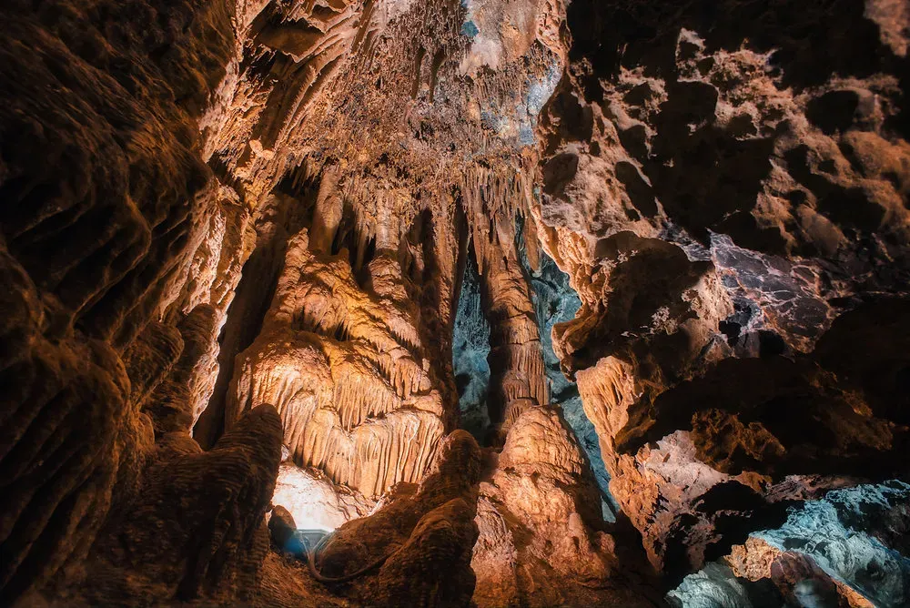Wide view of the illuminated main chamber inside Grutas de Nombre de Dios Chihuahua with towering stalactites and stalagmites formations