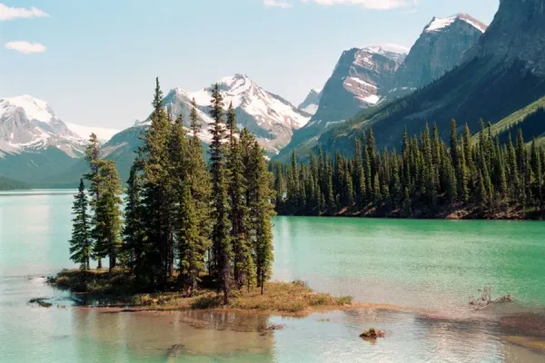 Spirit Island on Maligne Lake with turquoise waters surrounded by snow-capped Rocky Mountain peaks in Jasper National Park Canada