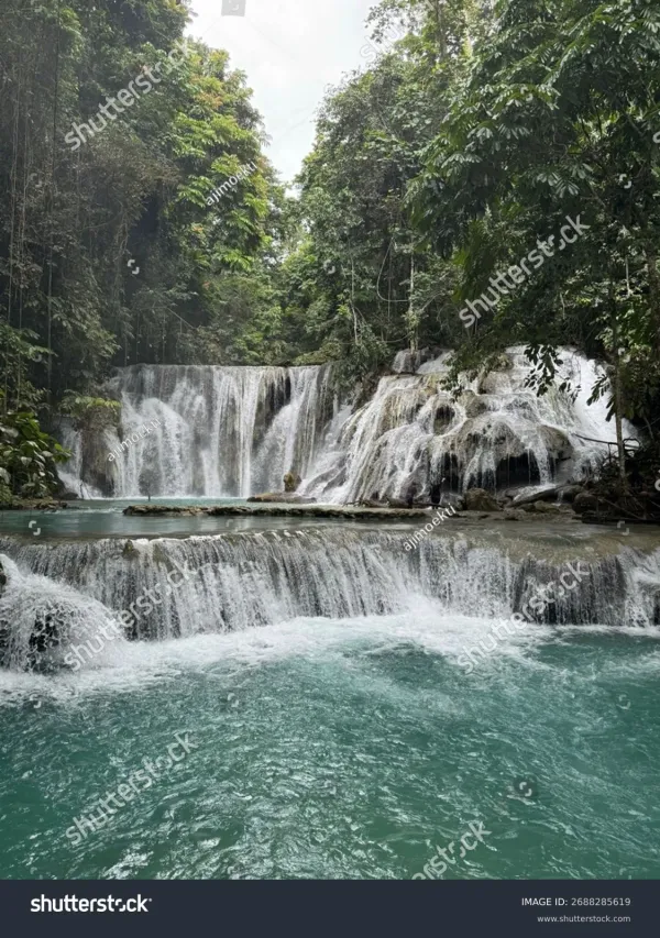 Aerial view of Piala Waterfall Indonesia multi-tiered turquoise cascades surrounded by lush jungle