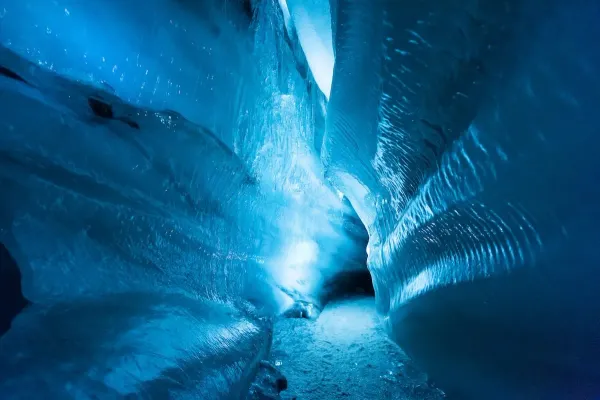 Vivid blue ice formations inside Svalbard ice caves with smooth sculpted walls in Norway