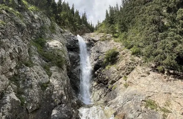 Barskoon Falls cascading down a rocky cliff in the Tien Shan mountains, Kyrgyzstan