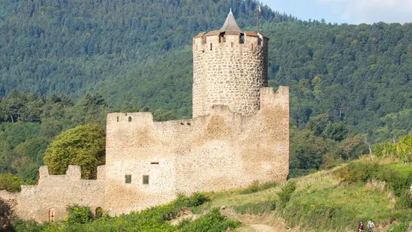 Kaysersberg Castle in France, a medieval ruin perched on a rocky hilltop overlooking the Alsatian village of Kaysersberg below